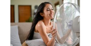 ženska se hladi pred ventilatorjem